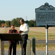 Two individuals looking at the Harriet Tubman sign