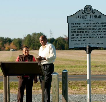 Two individuals looking at the Harriet Tubman sign
