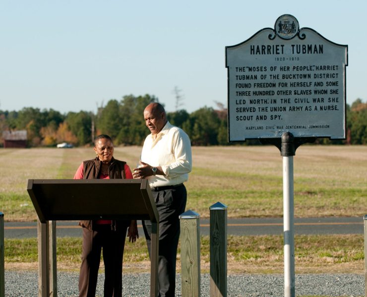 Two individuals looking at the Harriet Tubman sign