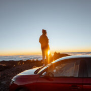 Girl looking at a sunset with a Car