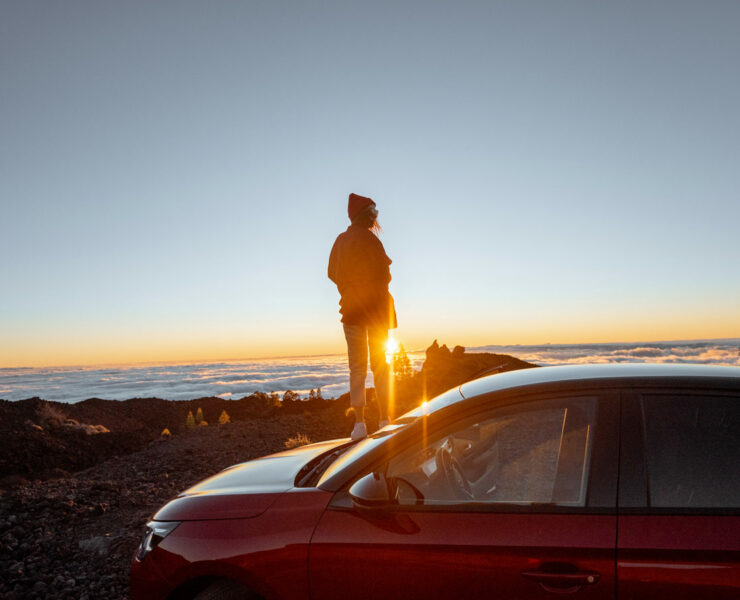 Girl looking at a sunset with a Car