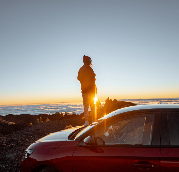 Girl looking at a sunset with a Car