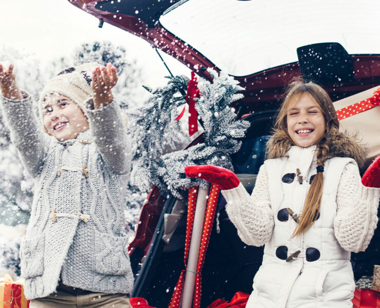 Kids sittin in truck of a car with presents