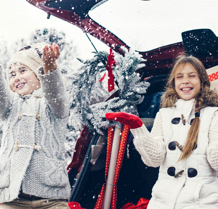 Kids sittin in truck of a car with presents