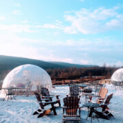 Adarondak chairs and a fire pit with igloos surrounding it in the outdoors
