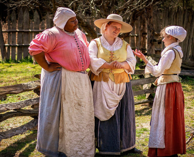 3 Actors standing outside in the sunlight in 17th Century Garb