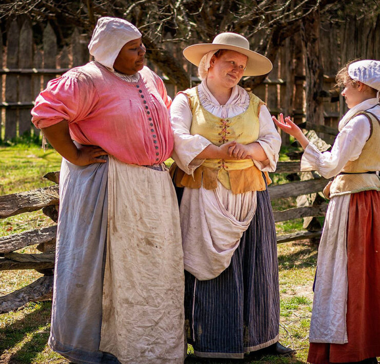 3 Actors standing outside in the sunlight in 17th Century Garb