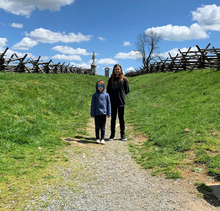 Two kids standing within the sunked road