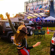 Girl dancing and looking at the stage with a band playing music on it