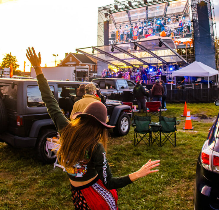 Girl dancing and looking at the stage with a band playing music on it