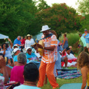 Image of a man playing a musical instrument within a crowd of people