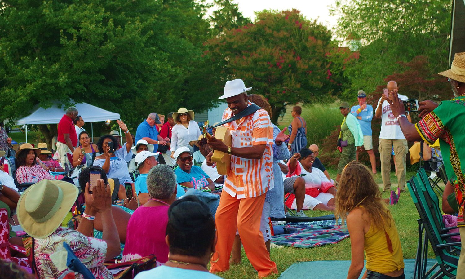 Image of a man playing a musical instrument within a crowd of people