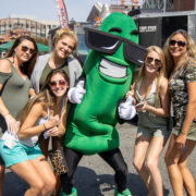 Group of people smiling at the camera with a pickle character