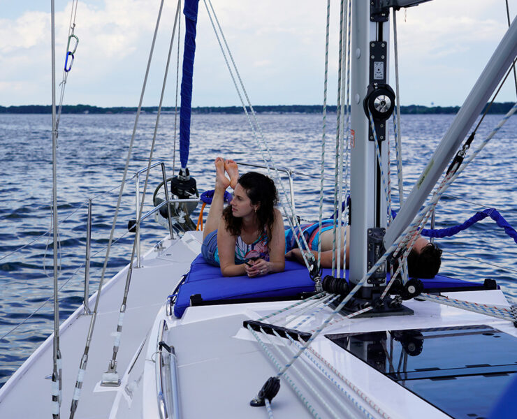 Man and woman laying on a boat that's on the water