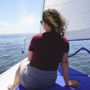 A woman sitting on a boat overlooking the water