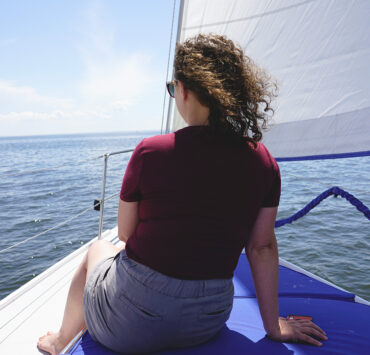 A woman sitting on a boat overlooking the water