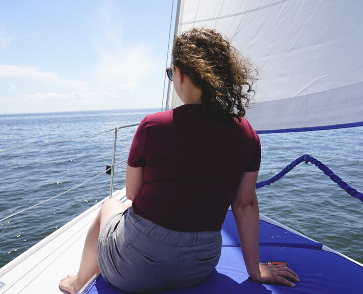 A woman sitting on a boat overlooking the water