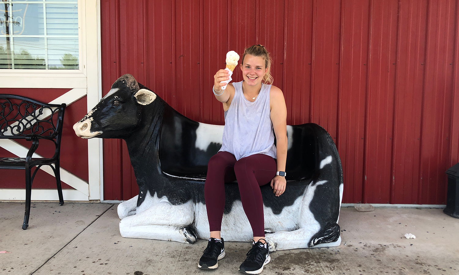 Woman sitting on a cow holding ice cream