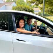 Two people sitting in a car looking out of the window