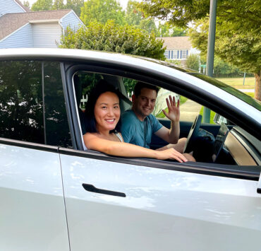 Two people sitting in a car looking out of the window