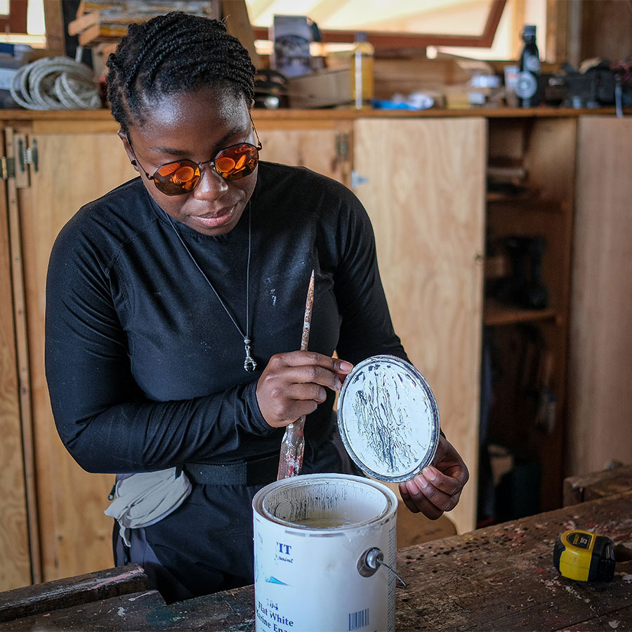 A woman opening a paint can