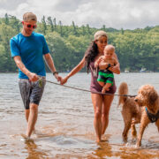 Mother, Father, and child walking a dog in the water