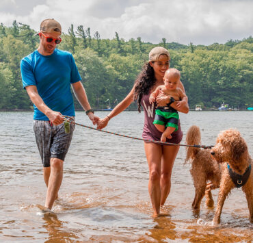 Mother, Father, and child walking a dog in the water