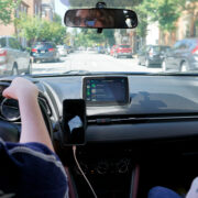 A girl driving a car with another person in the passenger seat