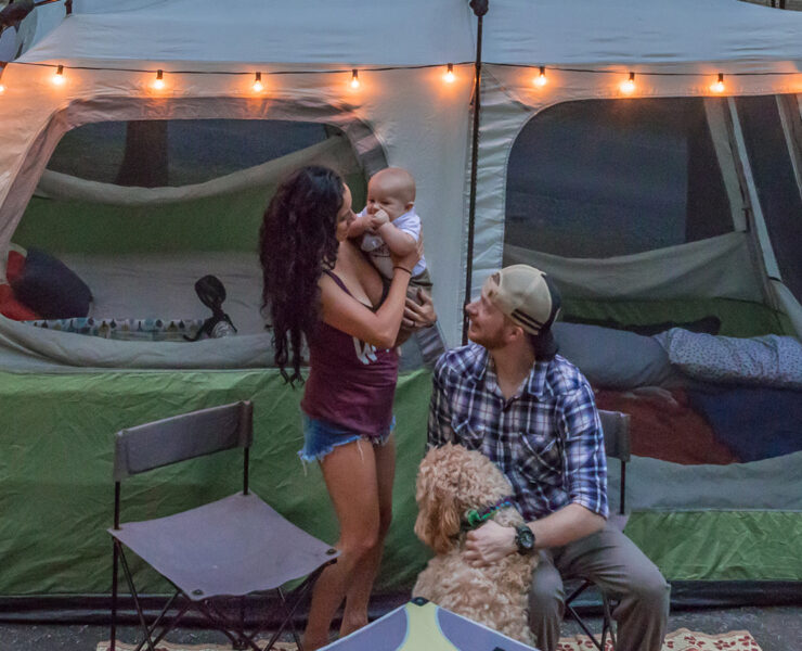 Mother, Father, and child in front of a tent with their dog