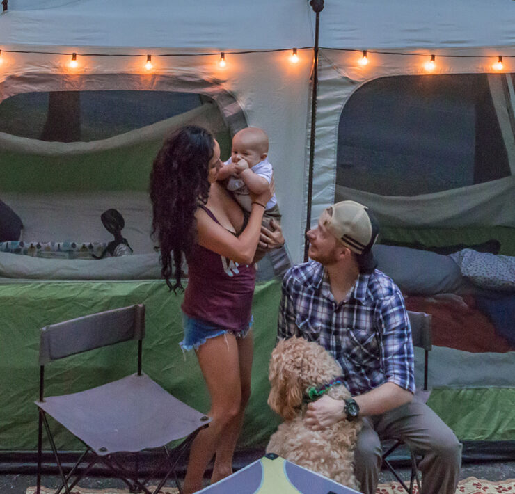 Mother, Father, and child in front of a tent with their dog