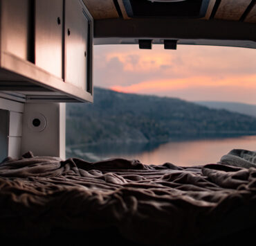 Looking out of a van onto the lake and a sunset