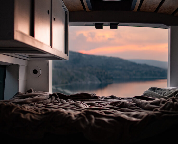 Looking out of a van onto the lake and a sunset