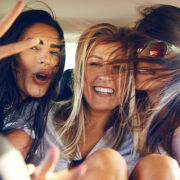 Girls with wind blowing in their hair showing peace signs