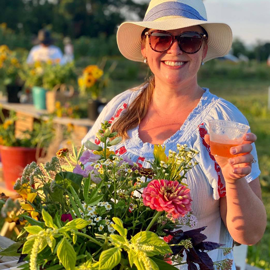 A woman holding a glass of wine with a bouquet of flowers