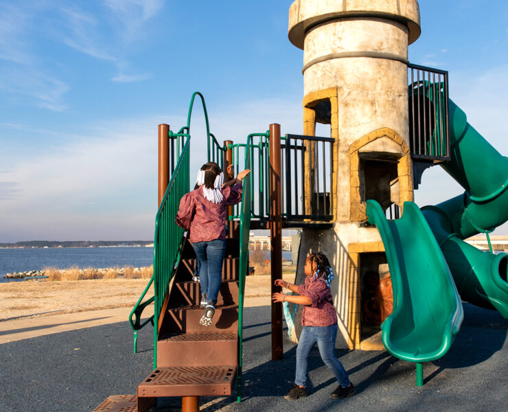 sisters on a playground by the water