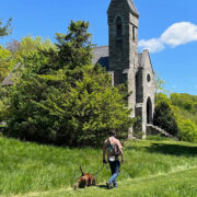 Man walking dog in front of Dahlgren Chapel