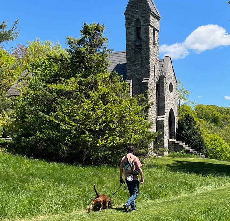 Man walking dog in front of Dahlgren Chapel
