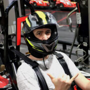Man in go-karting helmet giving shocka hand-sign to the camera
