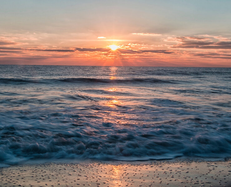 Sunrise on the water, waves crashing