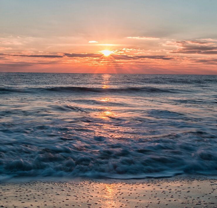 Sunrise on the water, waves crashing
