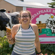 Person smiling holding up an ice cream cone