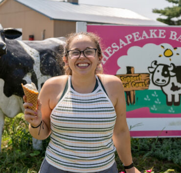 Person smiling holding up an ice cream cone