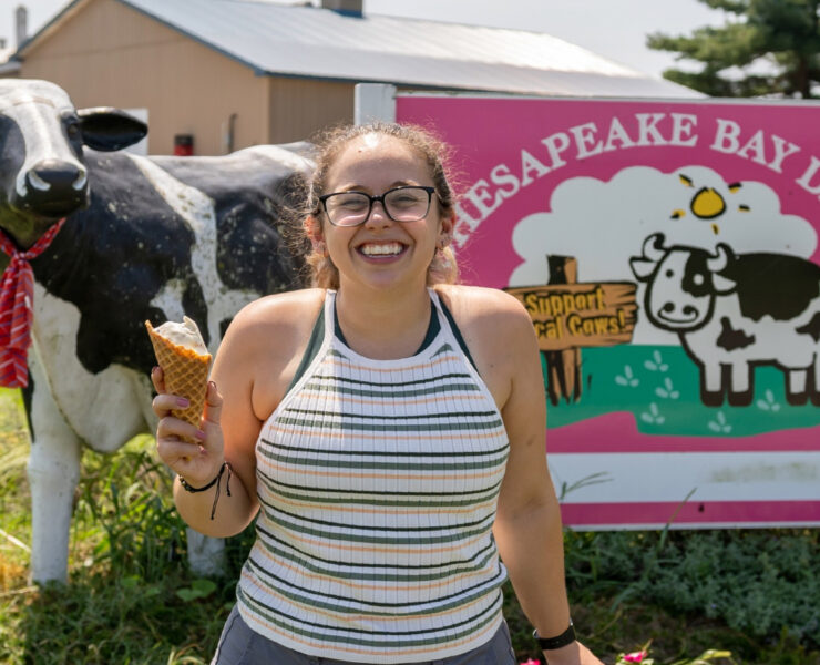 Person smiling holding up an ice cream cone