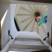 Young boy at the top of a lighthouse looking down the opening and ladder