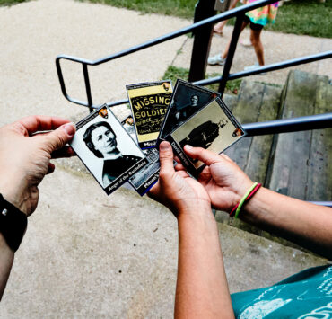 Children looking at National Park Service trading cards of people and places related to the Cara Barton National Historic Site