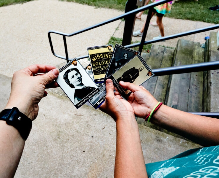 Children looking at National Park Service trading cards of people and places related to the Cara Barton National Historic Site
