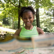 Young girl reading map in the forest