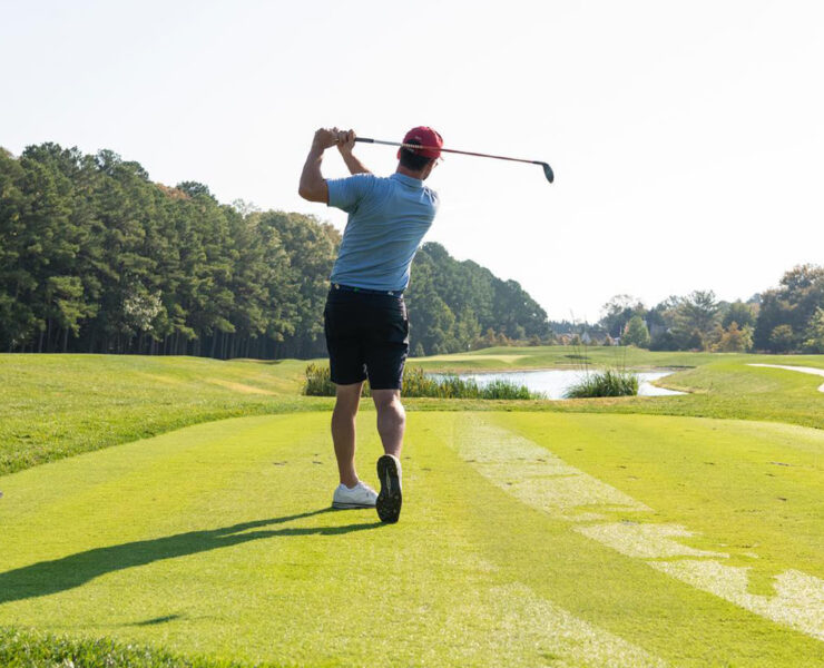 Person teeing off on a golf course