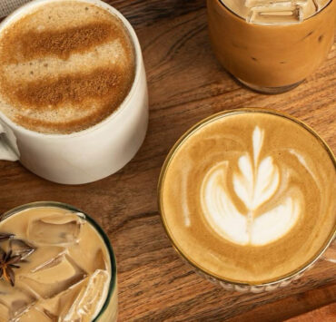 Multiple coffee beverages on a wooden table