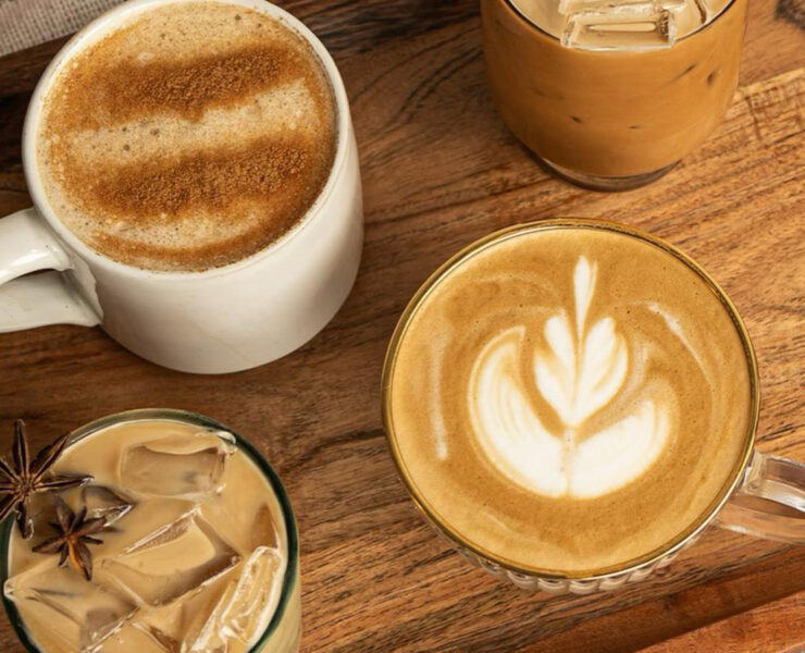 Multiple coffee beverages on a wooden table